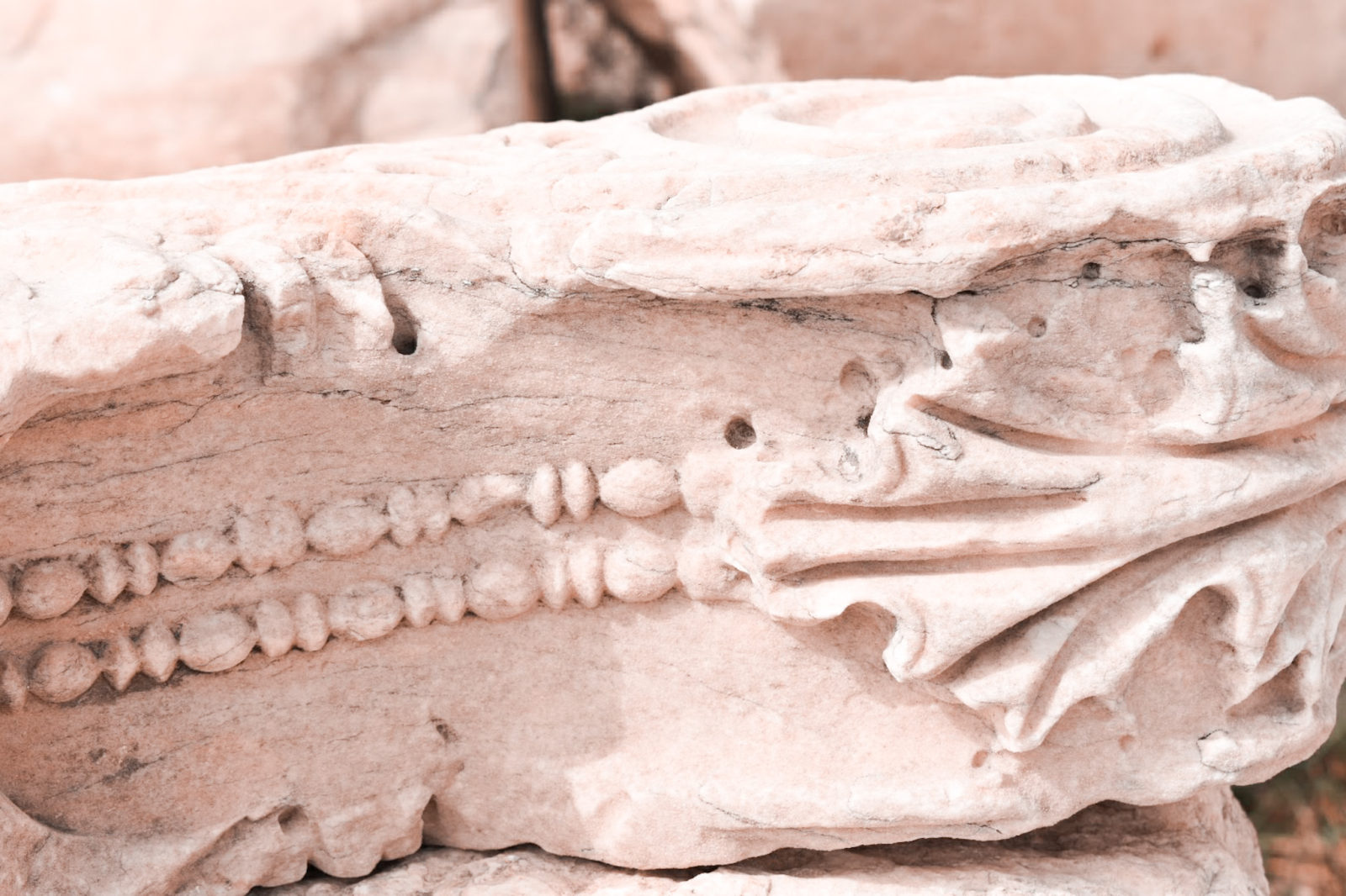 Close up photo of a marble chunk of the Acropolis with grape leaf carvings