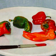 Five peppers on a plate with a knife