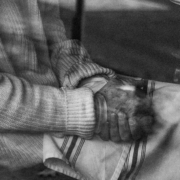 Black and white photo of a person with their hands in their lap
