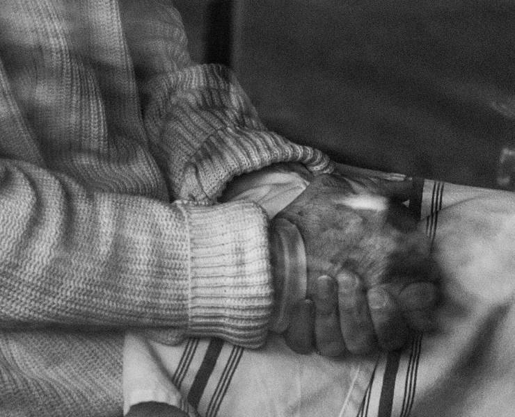 Black and white photo of a person with their hands in their lap