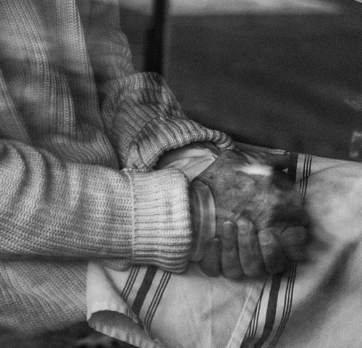 Black and white photo of a person with their hands in their lap