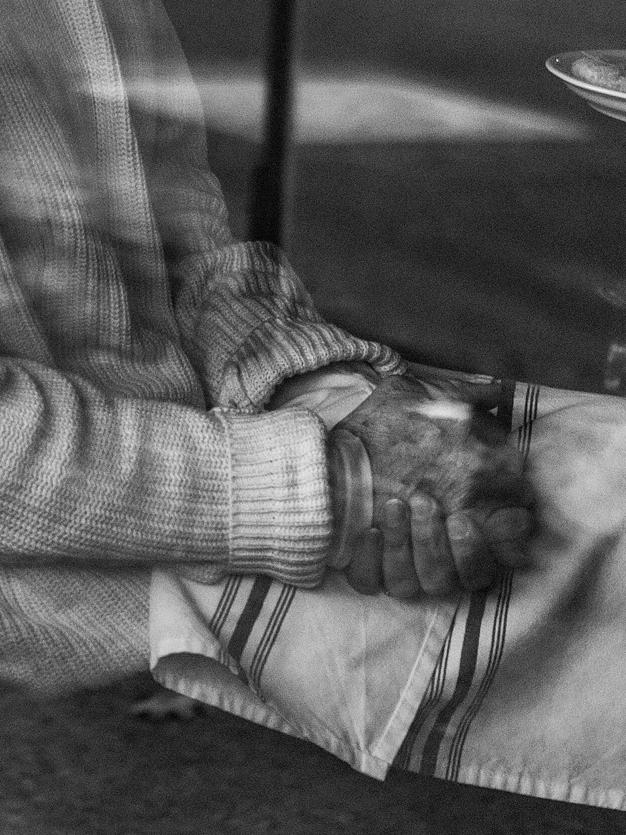 Black and white photo of a person with their hands in their lap