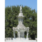 Photograph of a white stone fountain in front of a large tree