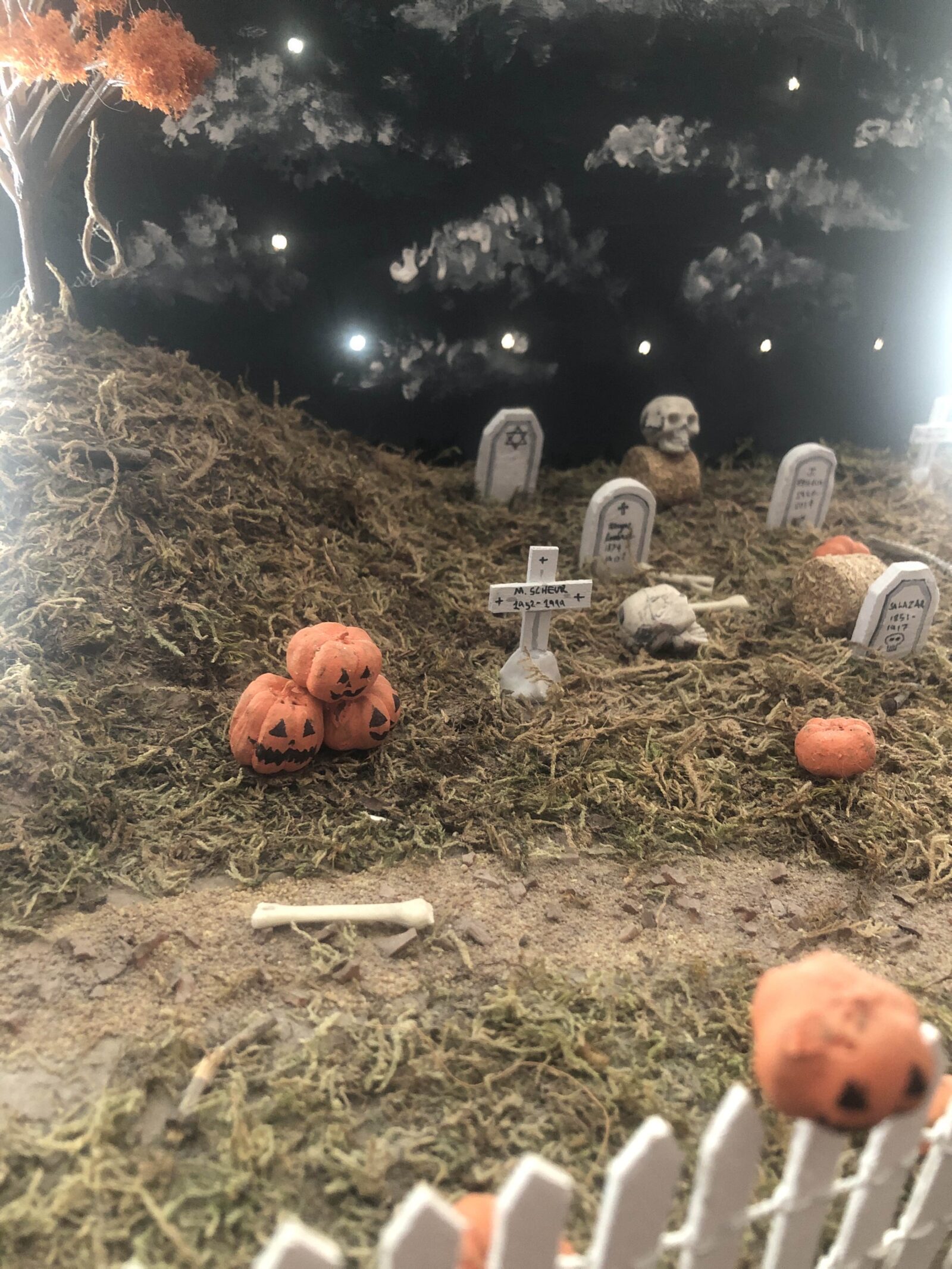 Miniature diorama of a graveyard with autumn trees and pumpkins