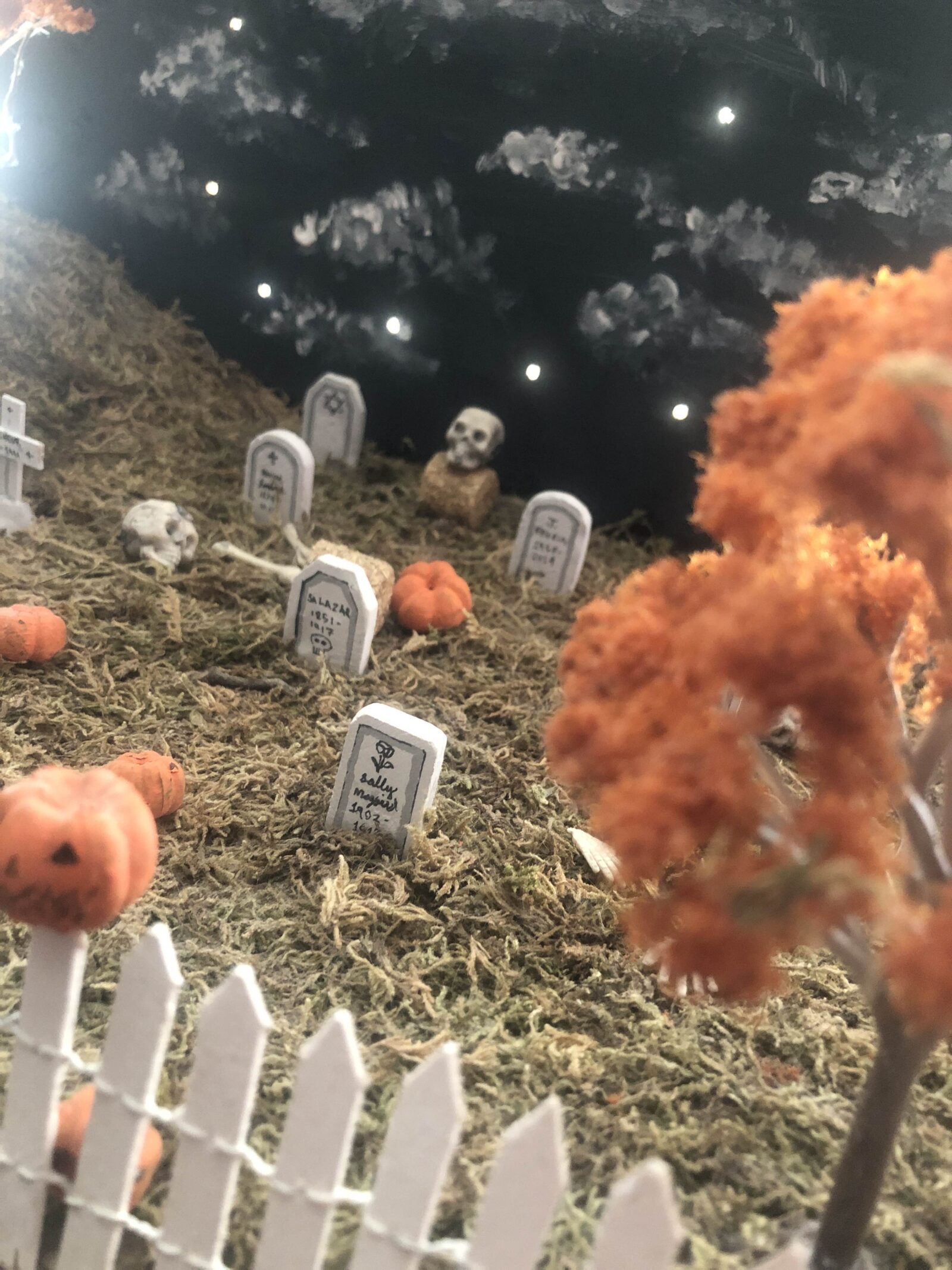 Miniature diorama of a graveyard with autumn trees and pumpkins