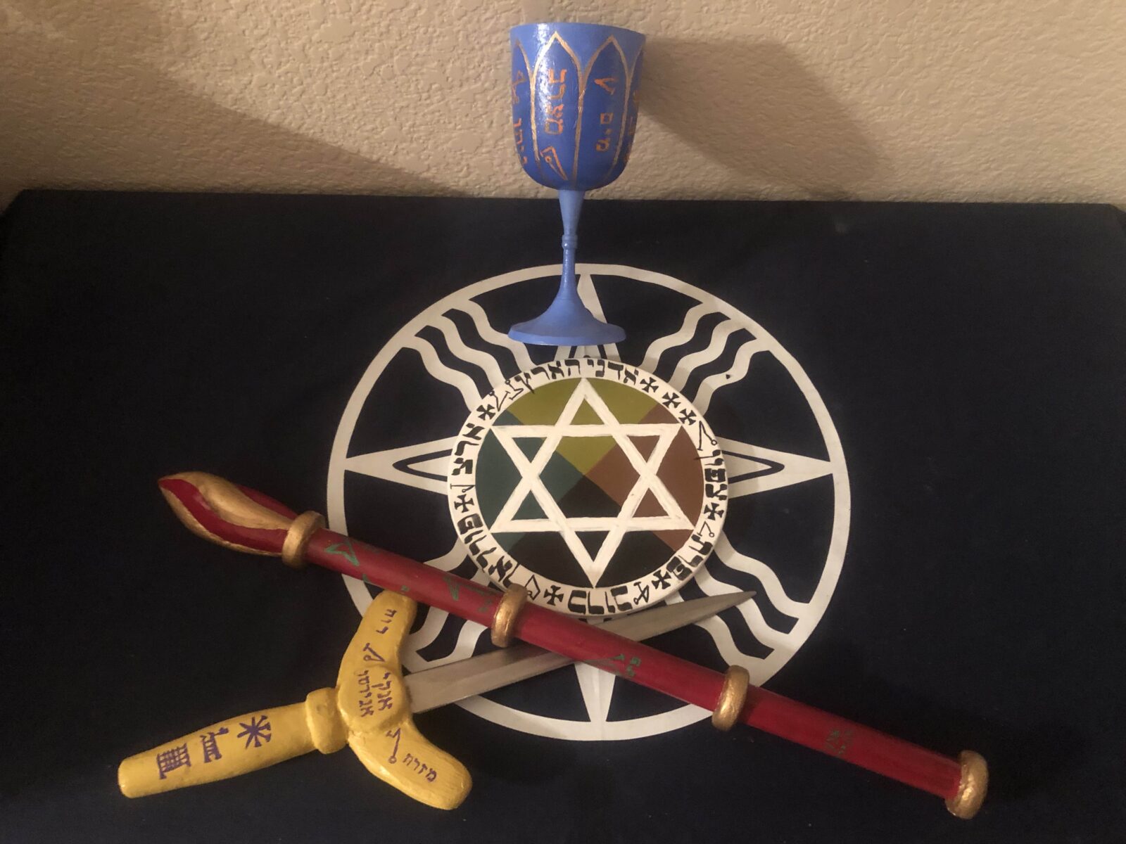 A selection of elemental tools of the Hermetic order of the golden dawn including a goblet wand and dagger