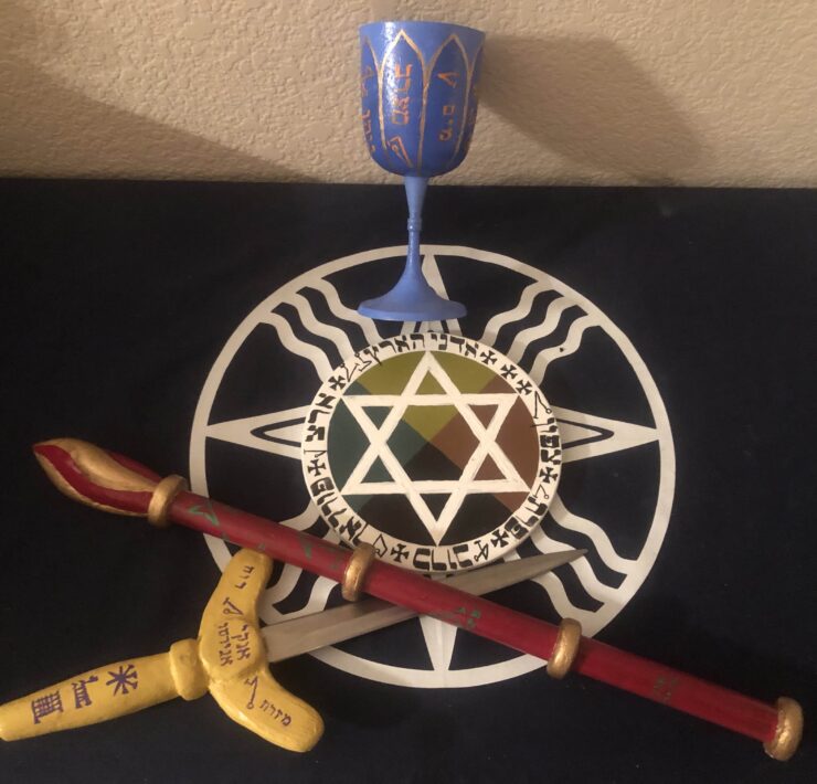A selection of elemental tools of the Hermetic order of the golden dawn including a goblet wand and dagger