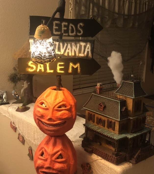 Three jack o lantern masks stacked on one another on a light pole