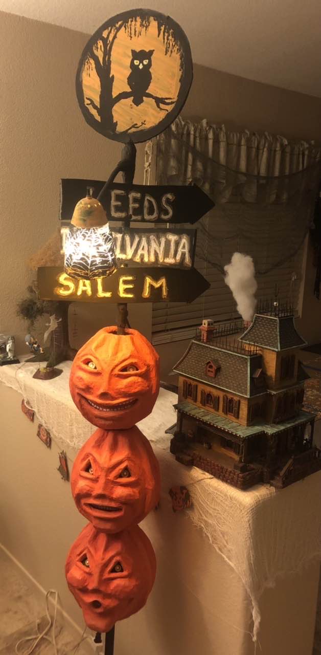 Three jack o lantern masks stacked on one another on a light pole